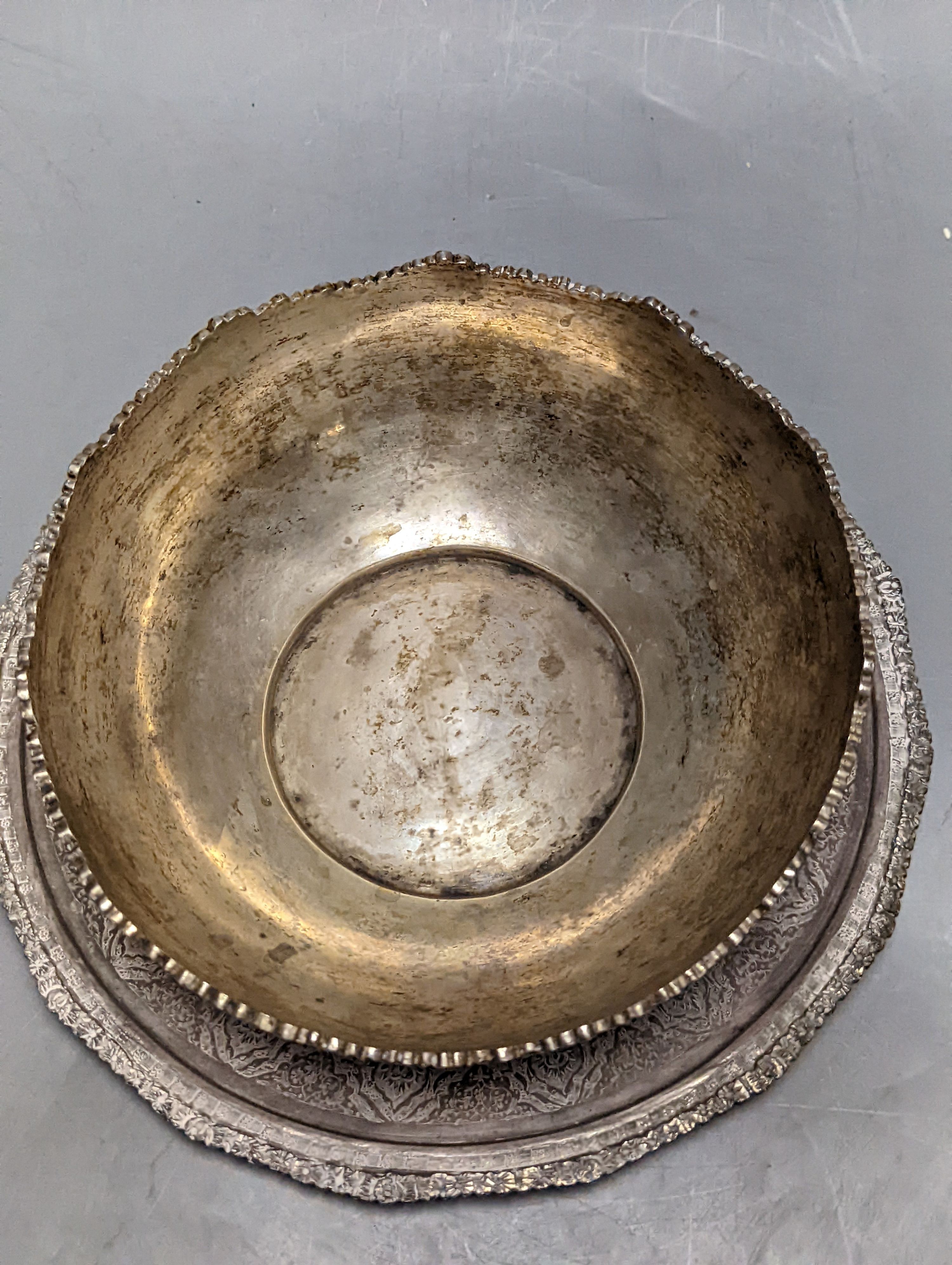 A Persian engraved white metal bowl, diameter 17.9cm and a similar stand or plate, 22cm, 20oz.
